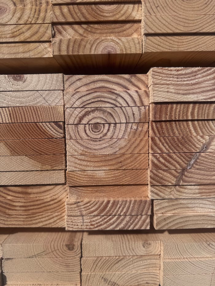Detailed view of neatly stacked wooden planks showcasing natural tree rings.
